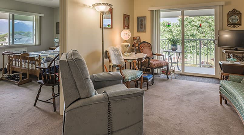 A cozy living room with comfortable seating and a view through a sliding door.