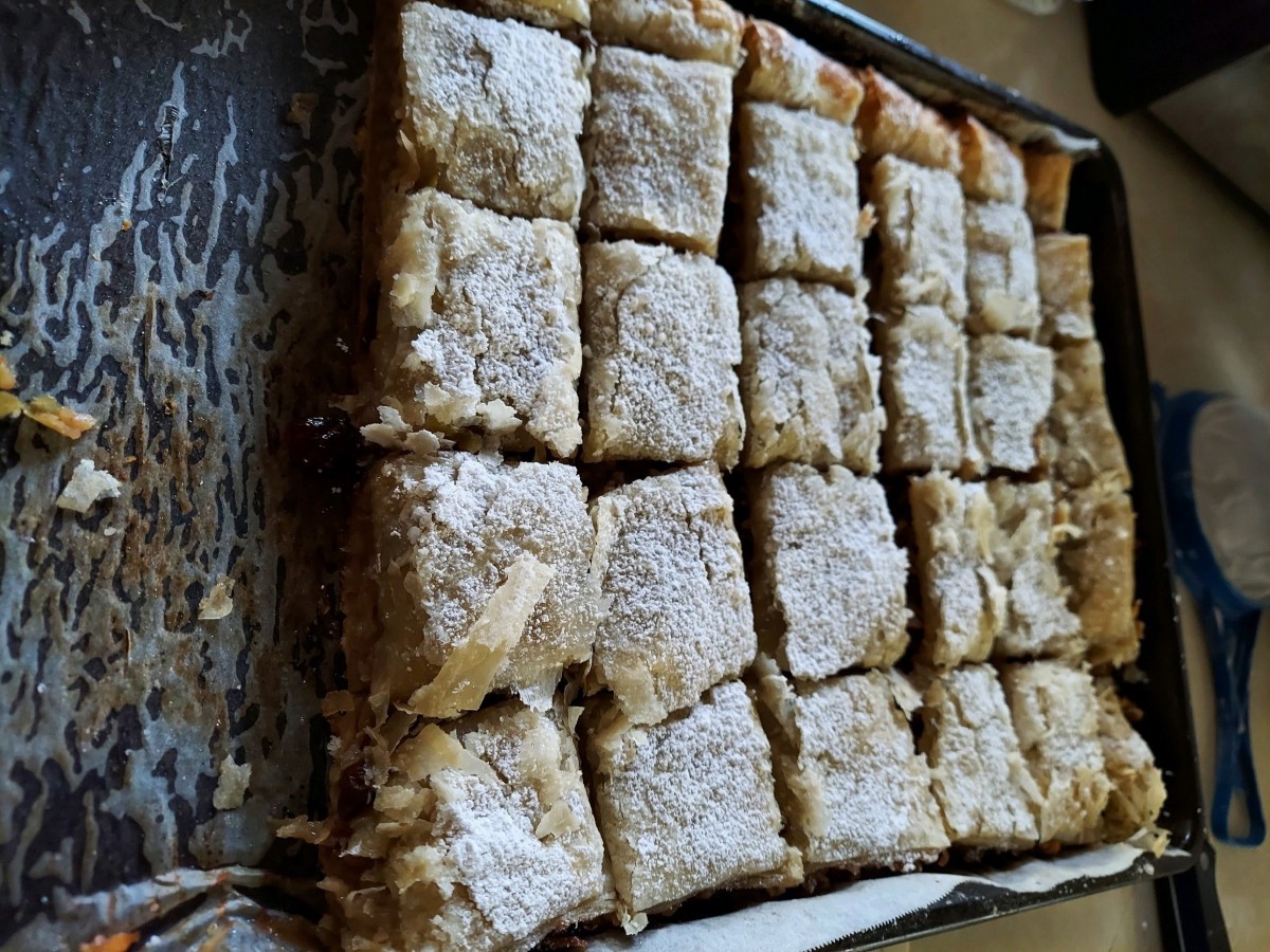 A tray of pastry squares topped with powdered sugar.