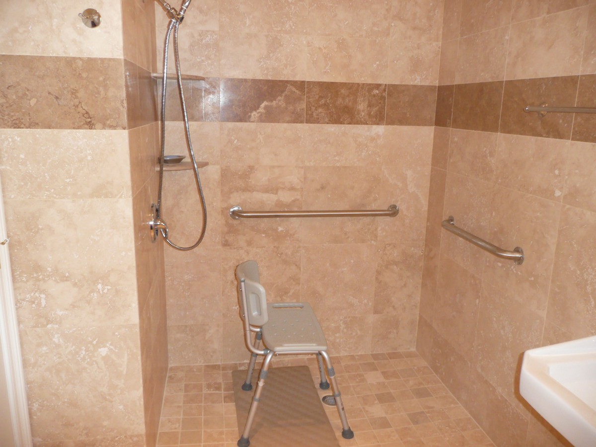 A walk-in shower with a shower chair and grab bars for accessibility.