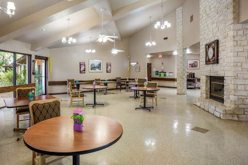 A spacious dining area featuring tables and chairs, illuminated by stylish light fixtures.