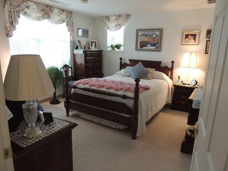 A cozy, traditionally styled bedroom with a large bed and elegant furnishings.