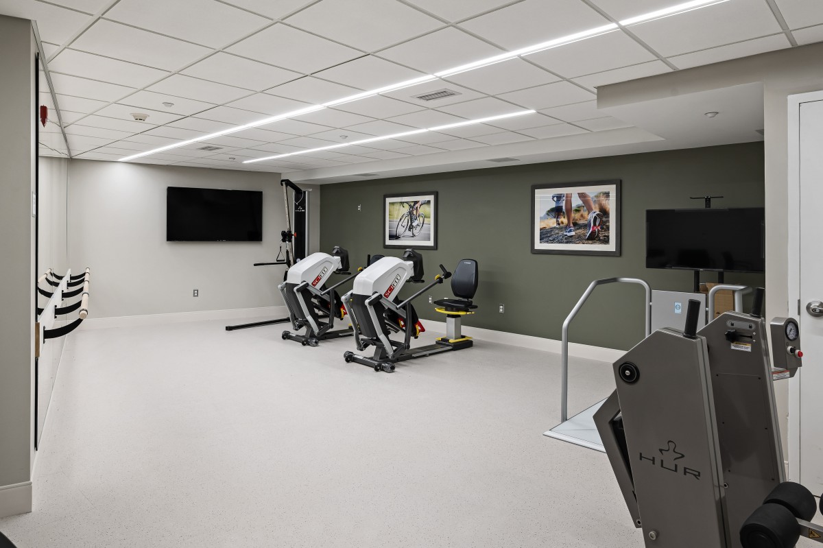 A modern gym with exercise equipment and a clean, spacious layout.