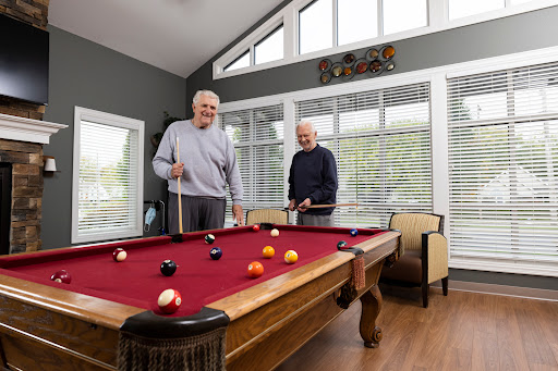 Two men enjoying a friendly game of pool in a bright and inviting game room.