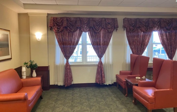 A cozy room with elegant curtains, sofas, and a table.