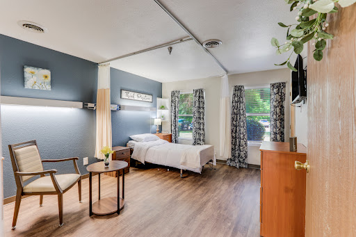 A well-lit and comfortable hospital room featuring modern furnishings and a cozy atmosphere.
