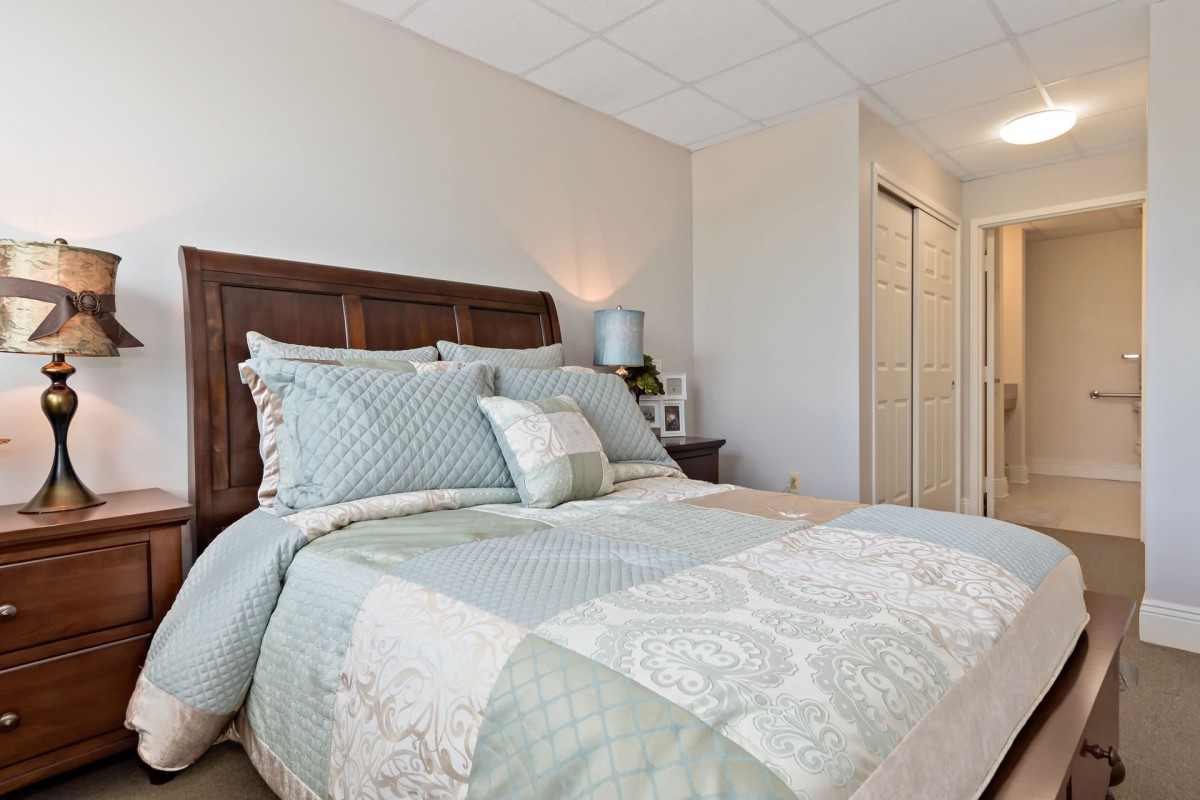 A cozy bedroom with a neatly made bed and soft lighting.