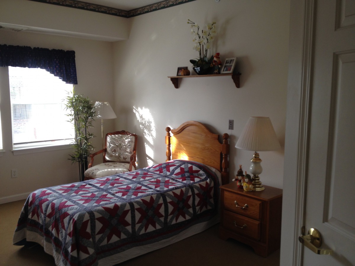Cozy bedroom with a single bed, quilt, and natural light streaming through the window.