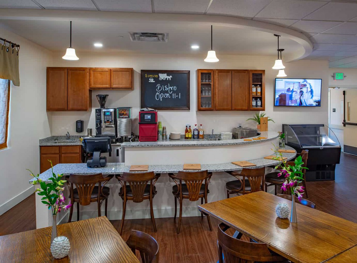 A cozy cafe interior with a bar counter and wooden furniture, creating a warm and inviting atmosphere.