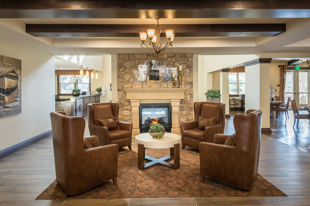A cozy living room with a stone fireplace surrounded by leather armchairs.