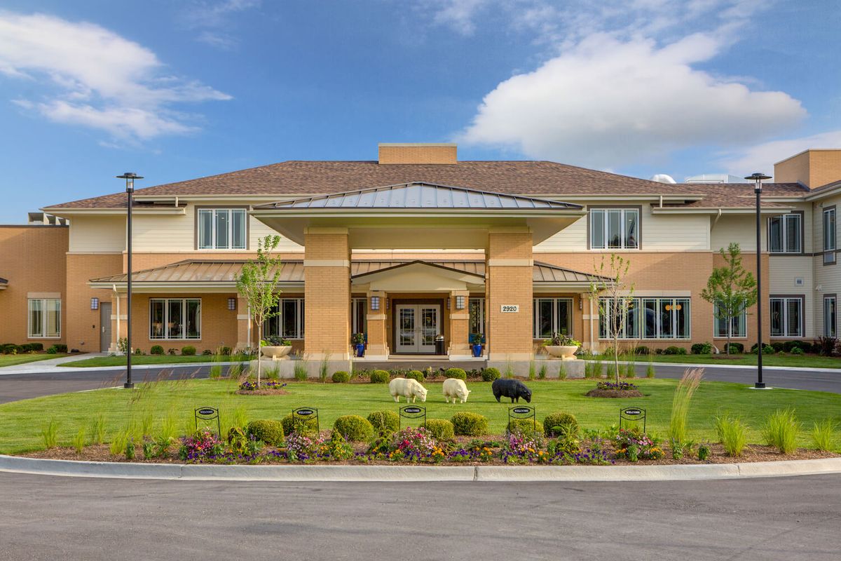 A large two-story house with well-maintained landscaping and a clear blue sky.