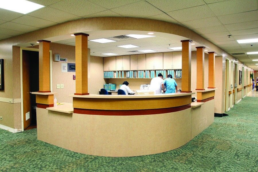 A hospital reception area with staff working at the desk.