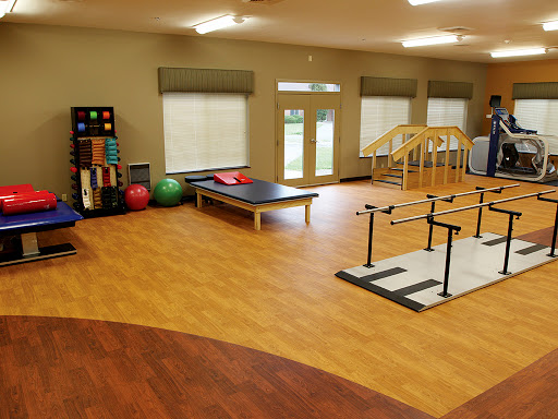 A spacious physical therapy room equipped with exercise equipment and various therapy tools.