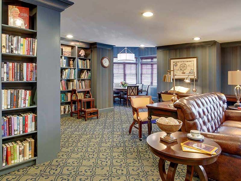 A cozy library interior with bookshelves, comfortable seating, and warm lighting.
