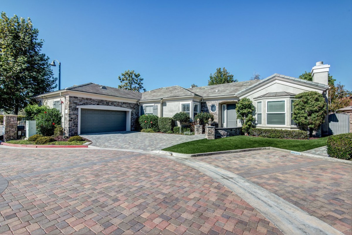 A suburban house with a driveway and garage, surrounded by neat landscaping.