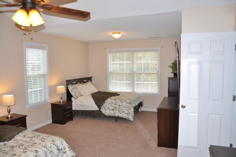 A cozy bedroom with two beds and ample natural light.