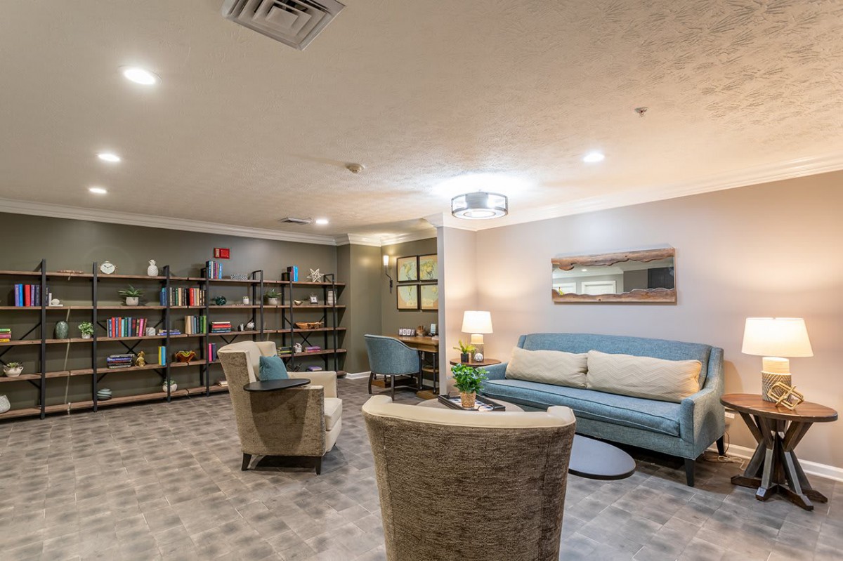 A cozy living room with modern furniture and bookshelves.