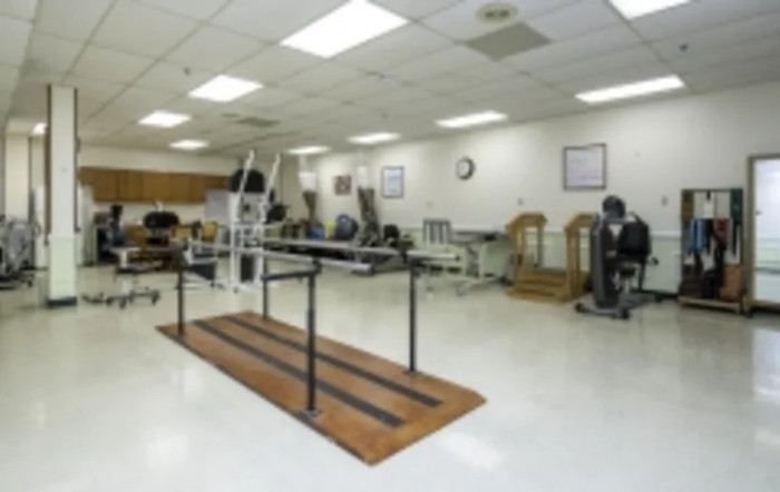 A spacious rehabilitation room equipped with various therapy and exercise machines.