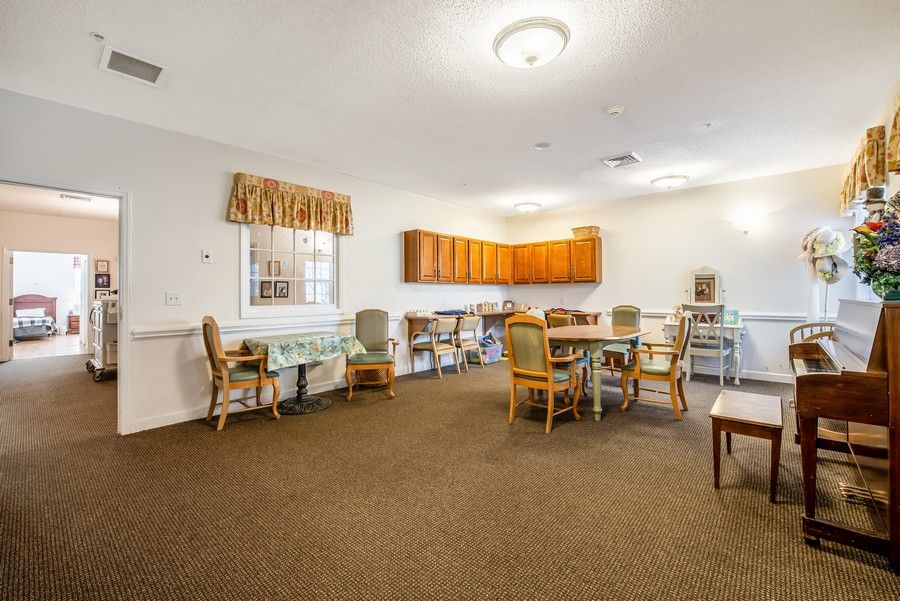 A communal dining and kitchen area with tables and chairs arranged for gatherings.