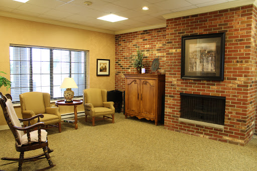 A cozy living room featuring a brick wall, comfortable seating, and a warm fireplace.