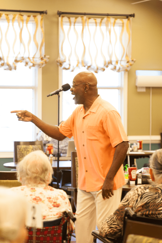 A man passionately sings into a microphone during an event.