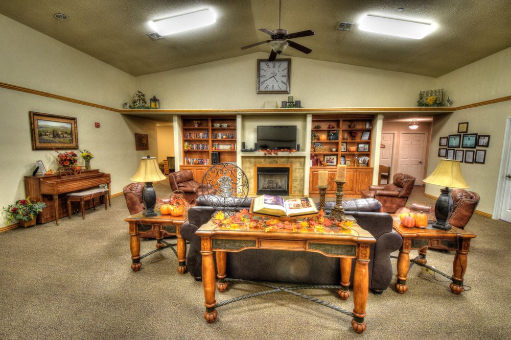 A cozy living room with a fireplace, shelves, and comfortable seating.