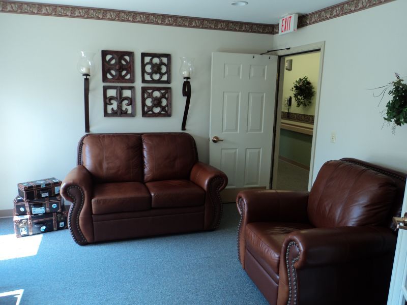 A cozy living room with leather couches and decorative wall art.