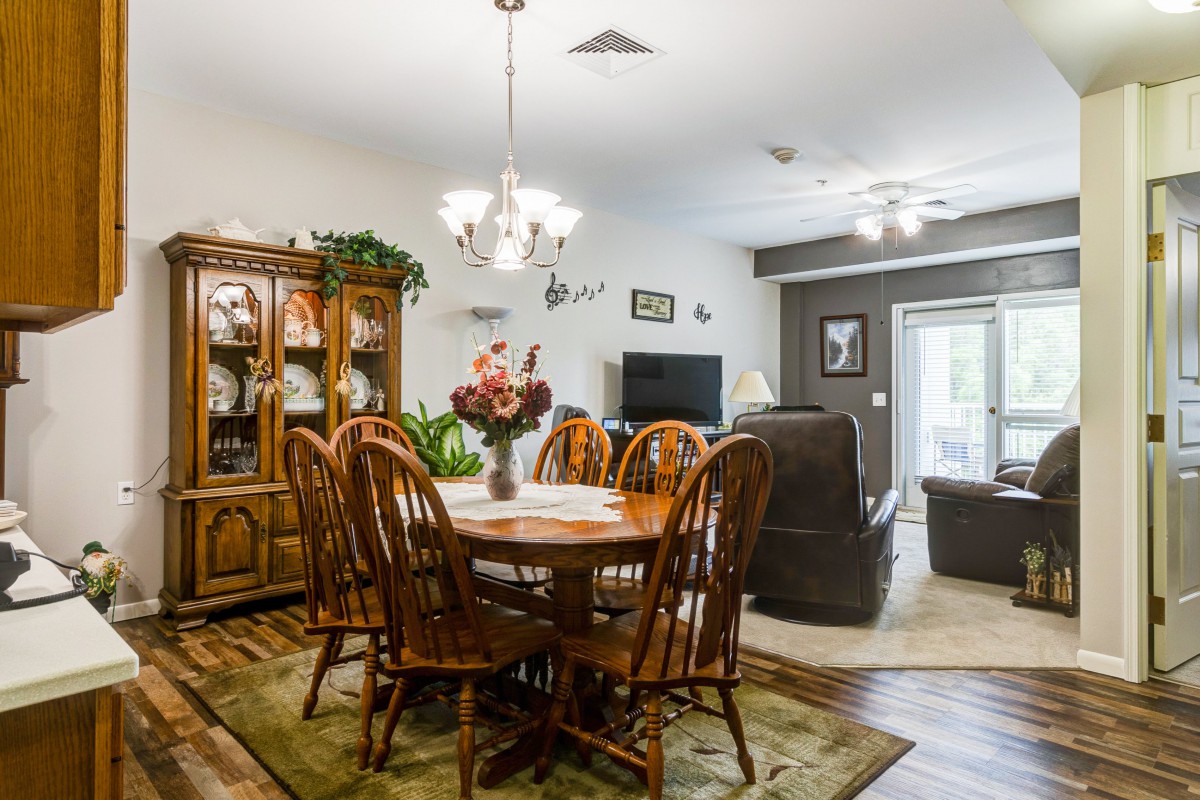 A cozy dining room with wooden furniture, a chandelier, and homey decor.