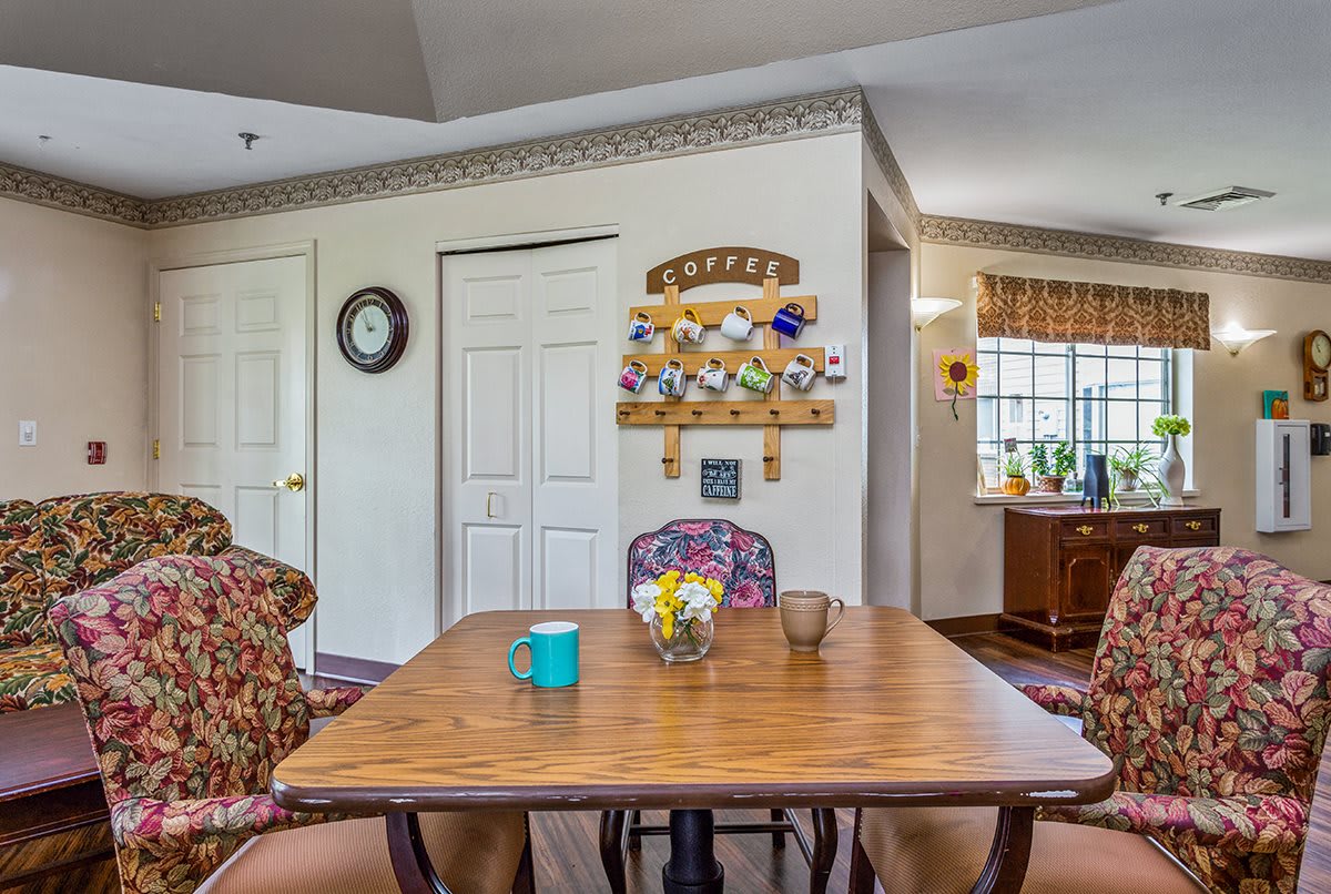 A cozy dining area with a wooden table and chairs, enhanced by wall decor and natural light.