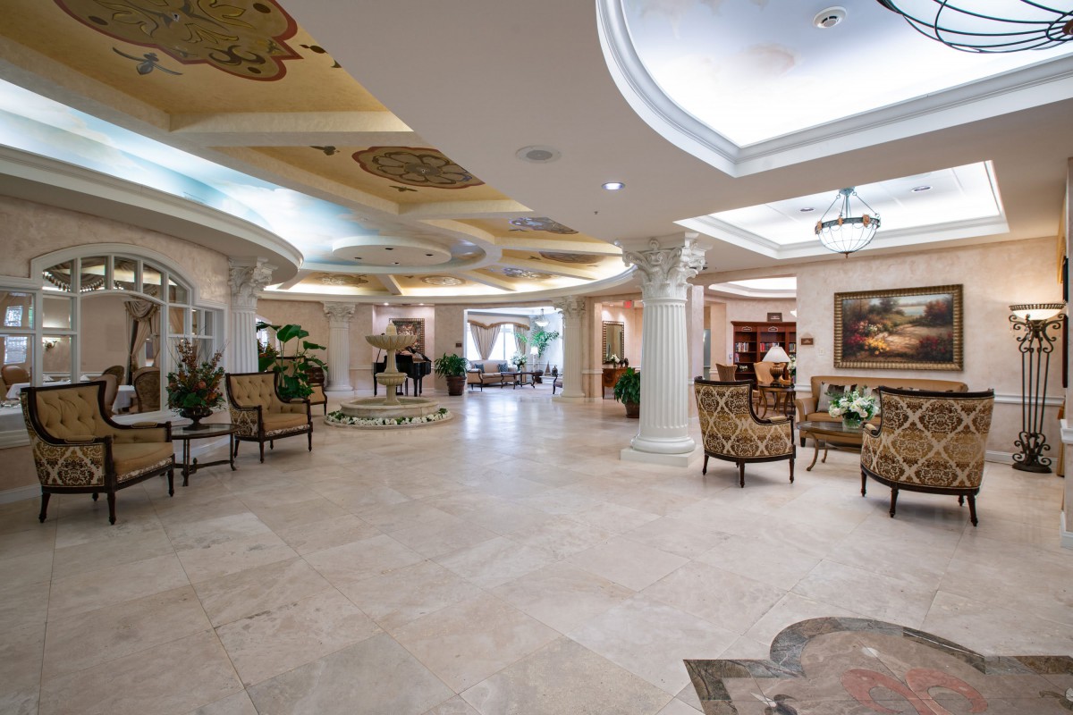 A luxurious lobby featuring marble floors, elegant seating, and detailed ceiling artwork.