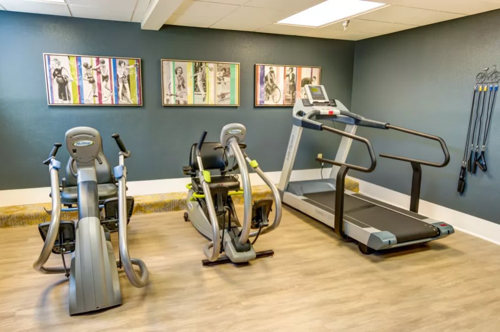 A small fitness room with various exercise equipment including treadmills and a stationary bike.