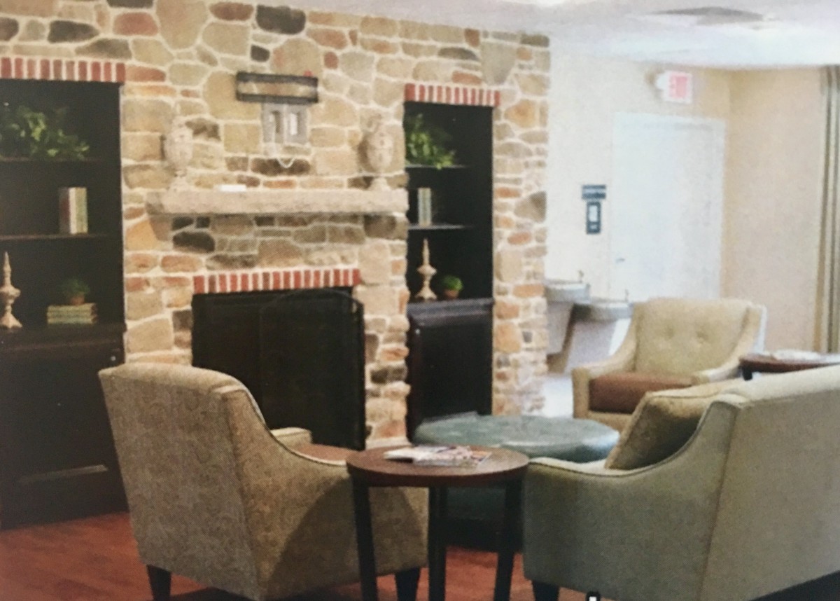A cozy living room with a stone fireplace and comfortable armchairs.