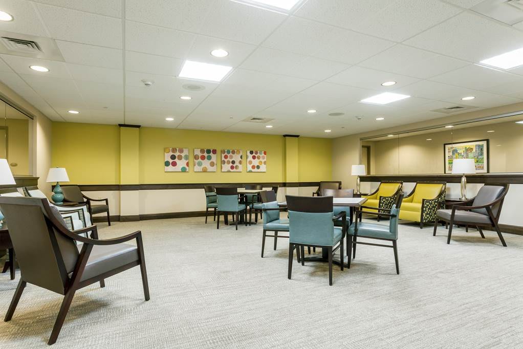 A spacious, modern lounge area with chairs and tables arranged for meetings or relaxation.