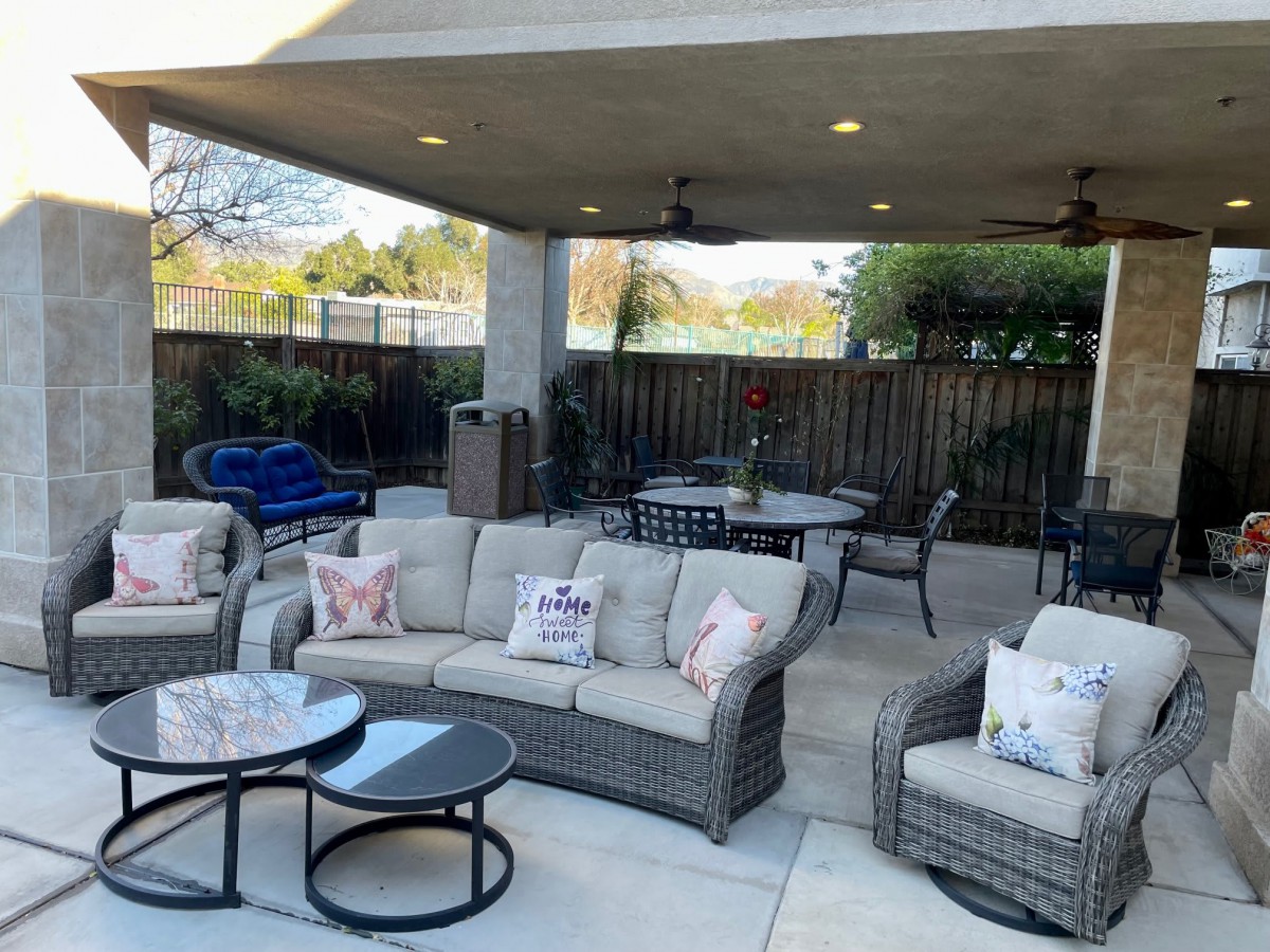 A stylish patio with comfortable outdoor seating and a dining area under a covered space.