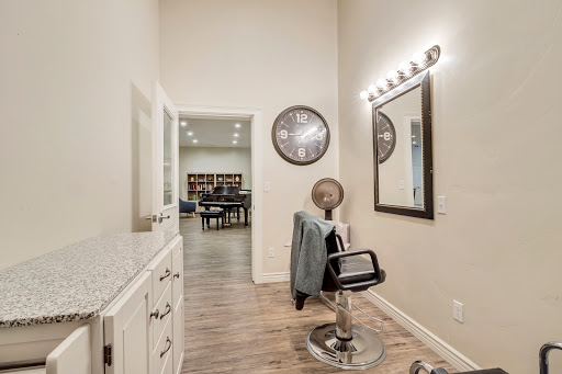A stylish and modern salon space featuring a barber chair and well-placed lighting.