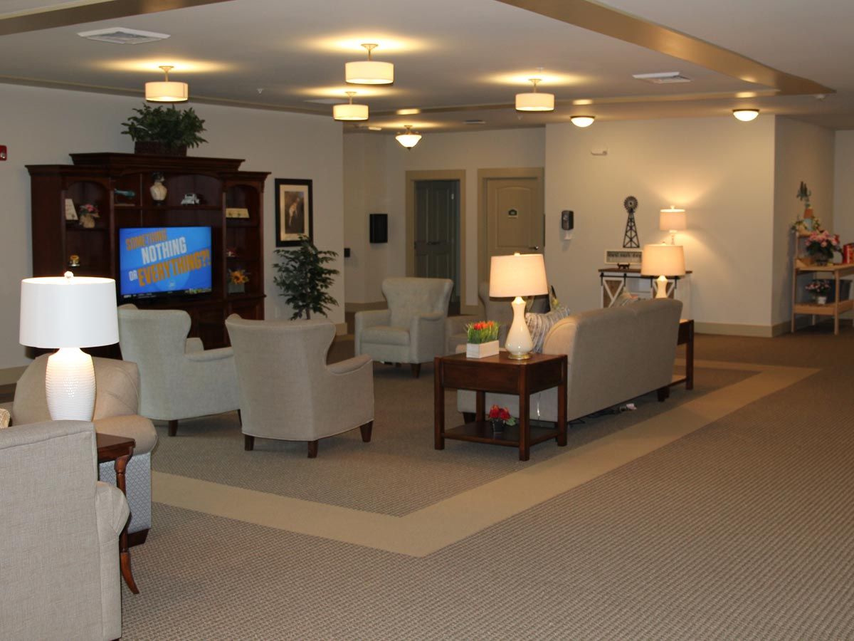 A cozy living room with sofas, a television, and stylish lighting.
