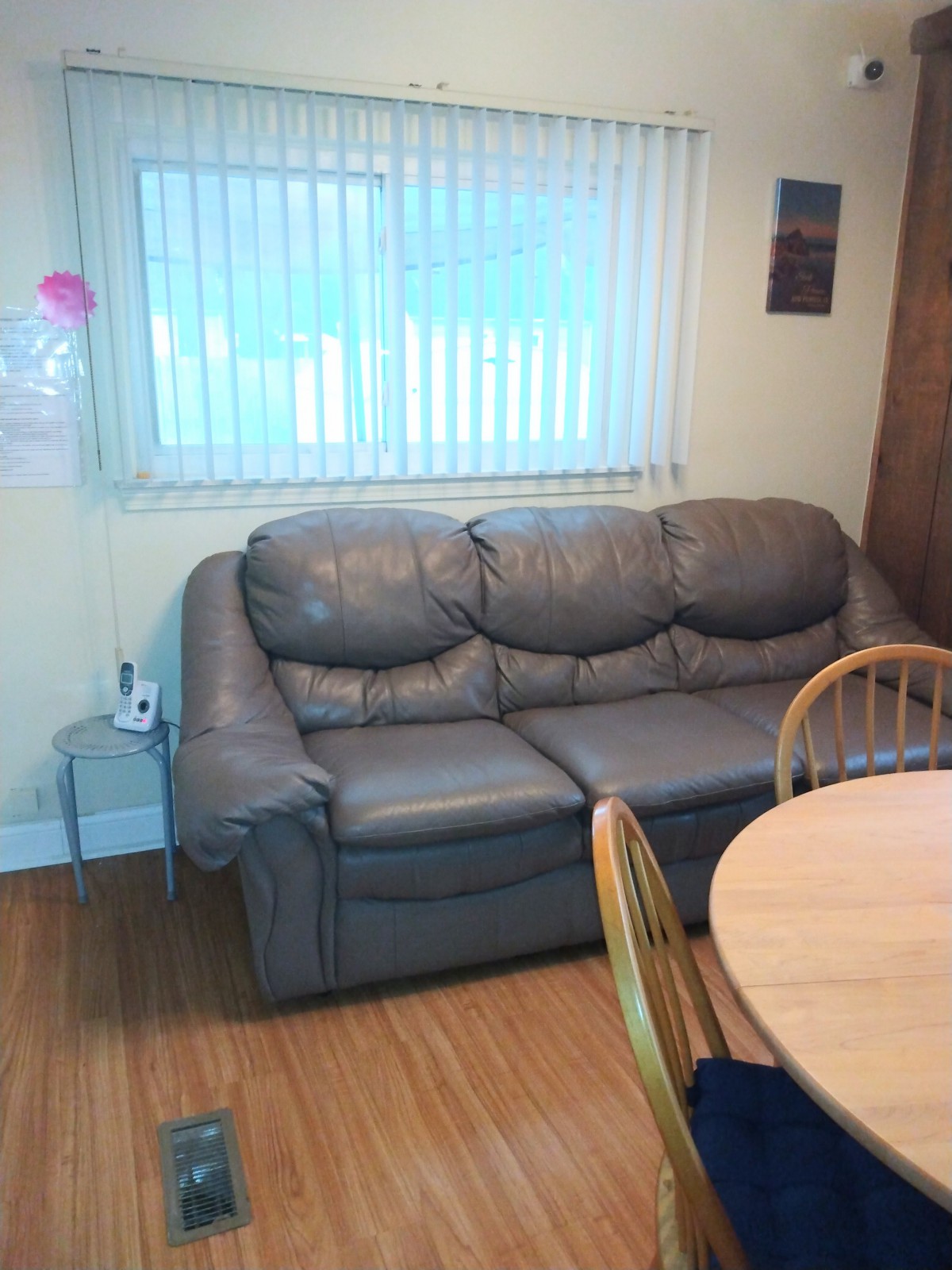 A cozy living room with a gray sofa next to a dining area.