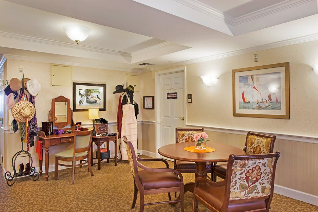 A cozy interior seating area with tables, chairs, and decorative artwork.