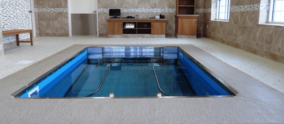 An indoor therapy pool equipped for rehabilitation exercises.