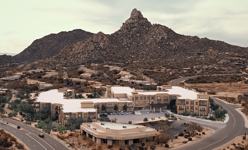 A luxury resort nestled in a scenic desert landscape with towering mountains in the background.