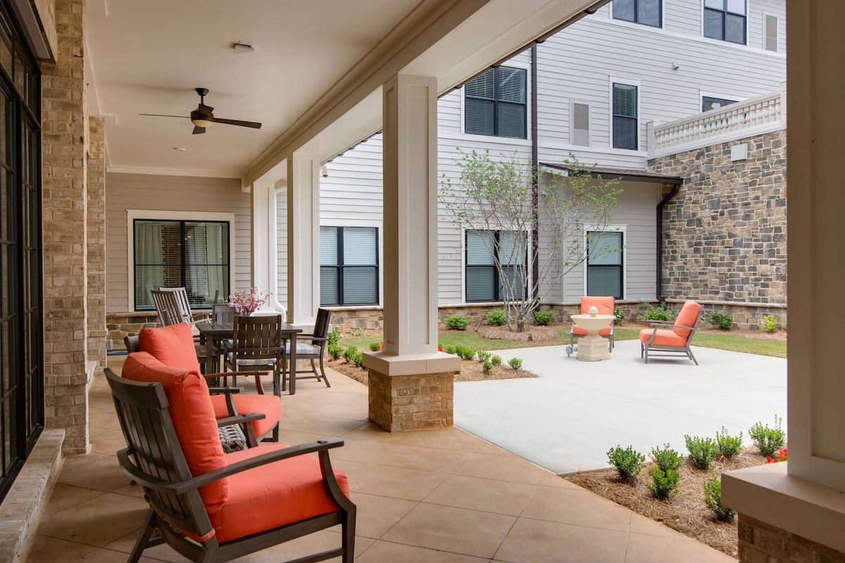 A cozy outdoor patio with seating and a view of the courtyard.
