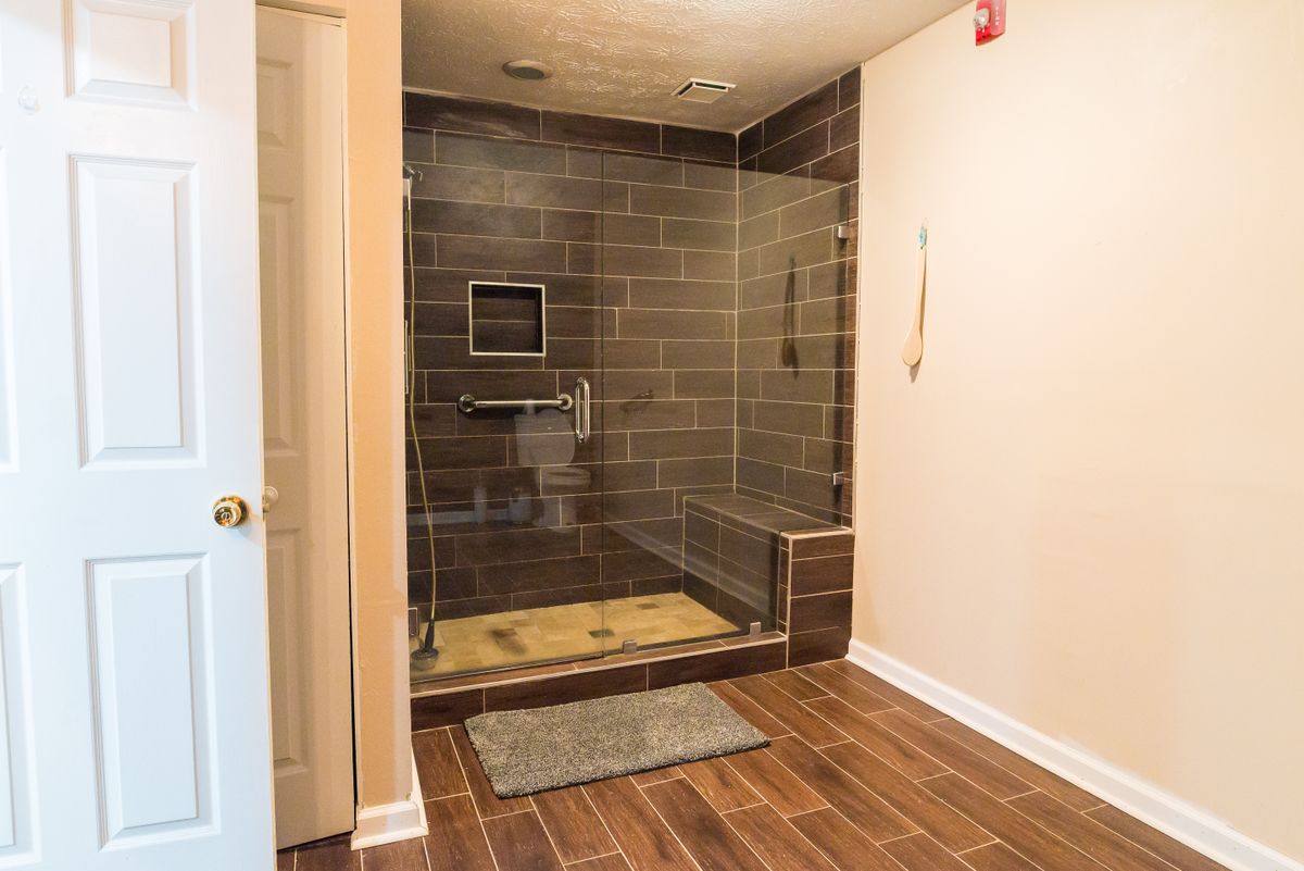 A modern bathroom featuring a glass-enclosed shower with dark tiles and sleek fixtures.