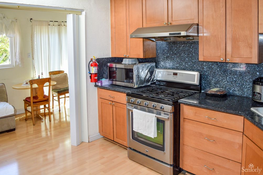 A modern kitchen with wooden cabinets featuring a stove, oven, and microwave.