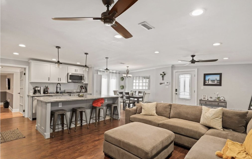 A stylish open-concept living room and kitchen combination with modern furnishings and ample natural light.