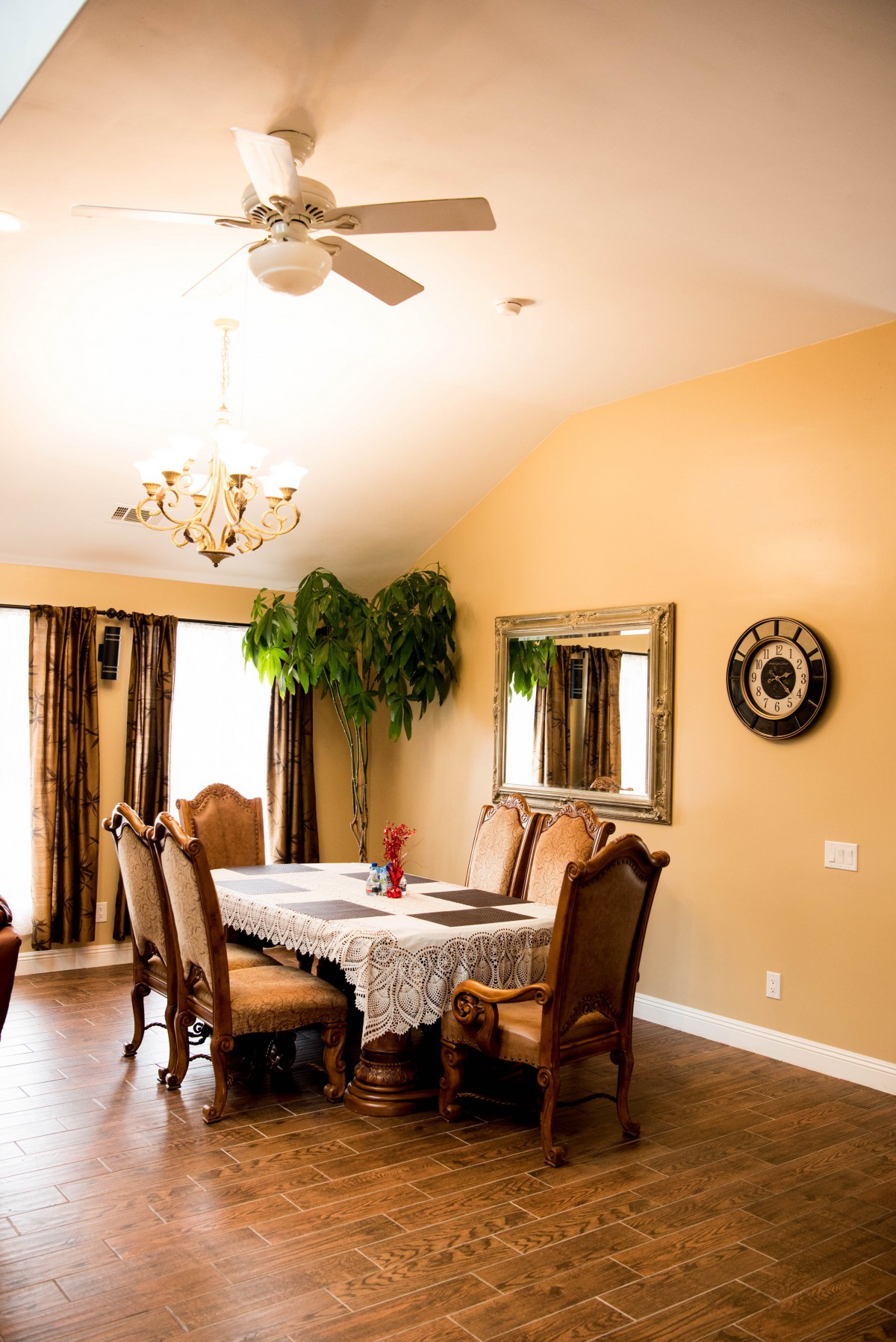 A warm and elegant dining room with a chandelier, wooden furniture, and decorative elements.