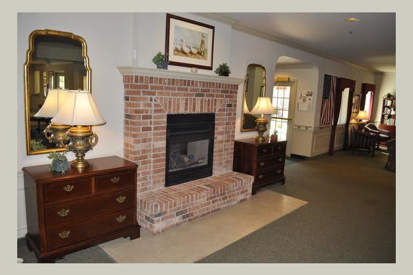 A cozy living room featuring a brick fireplace surrounded by elegant furniture and decor.