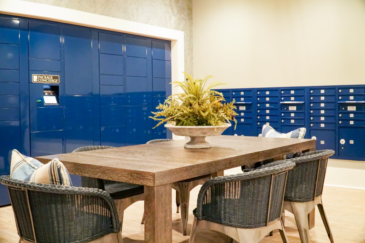 A modern dining area featuring a wooden table with wicker chairs and a decorative plant centerpiece.