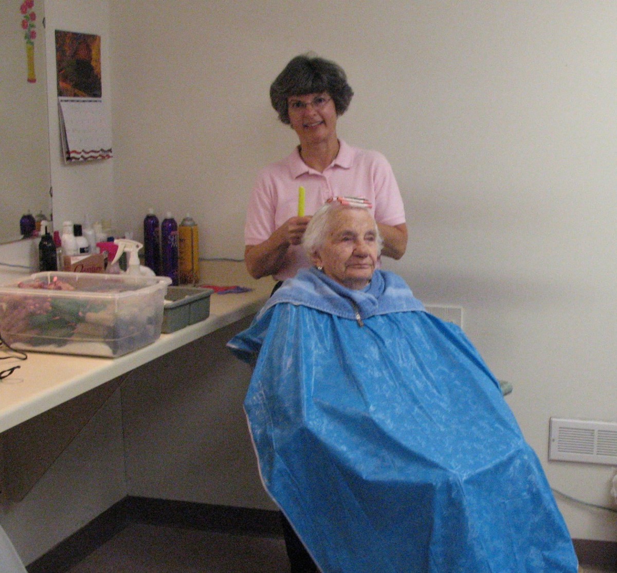 A hairdresser giving a haircut to an elderly person in a salon.