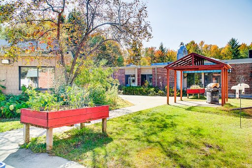 A vibrant outdoor space showcasing a garden and a cozy seating area, perfect for enjoying the fall scenery.