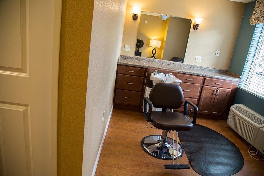 A well-lit salon space with a barber chair and mirror.