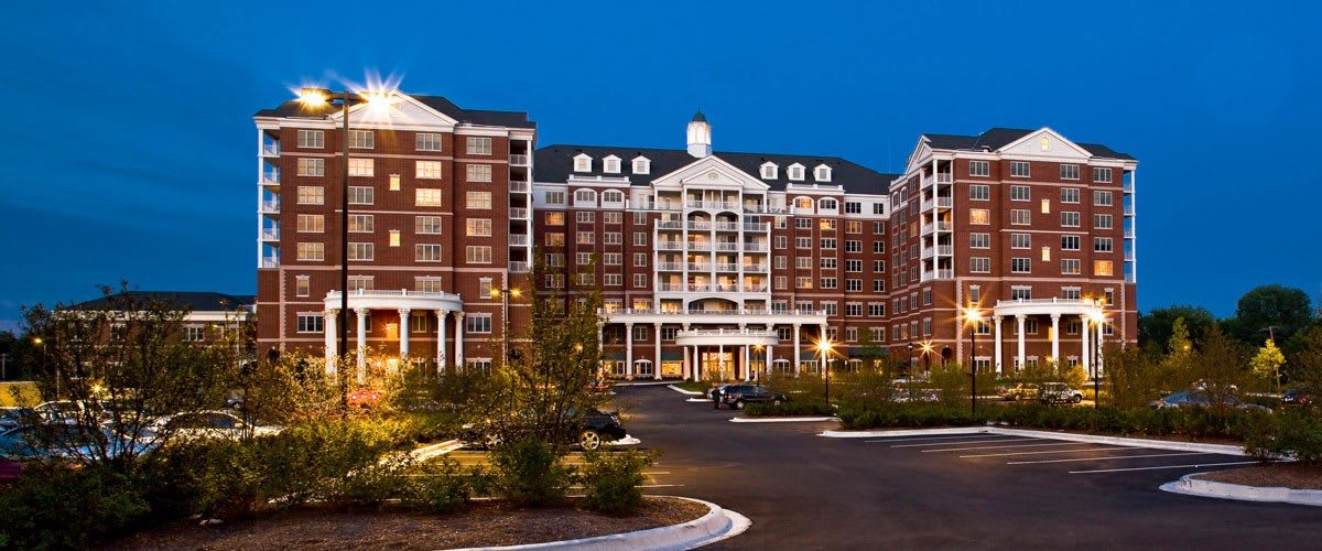 A well-lit hotel exterior with classic architecture during nighttime.